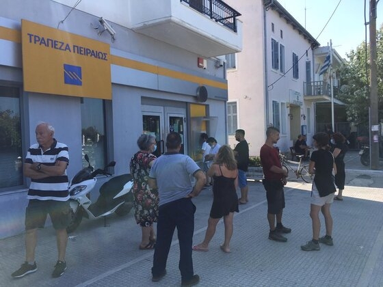 Η αναμονή του κόσμου έξω από το κατάστημα της τράπεζας Πειραιώς.